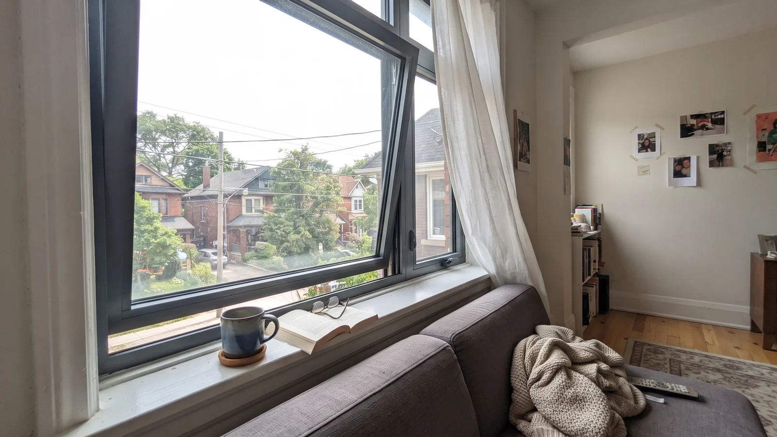 European tilt-and-turn aluminium window tilted open in a bright Toronto living room