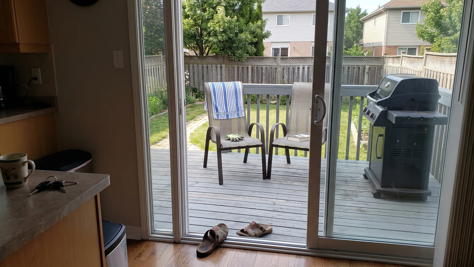 Wide sliding patio door open onto the backyard deck of a GTA home